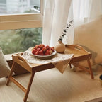 Bamboo bed tray with legs and handles set on a floor rug