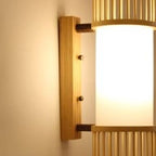 Slim cylinder wall sconce with bamboo slats and a white diffuser