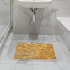 Dark bamboo mosaic bath mat in a white marble bathroom