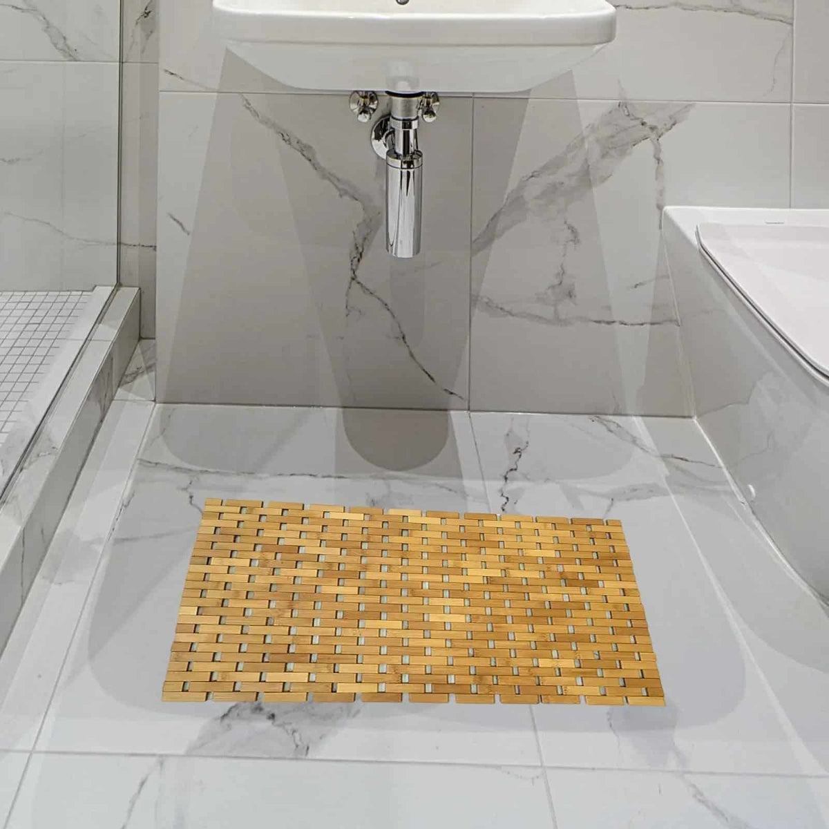 Dark bamboo mosaic bath mat in a white marble bathroom