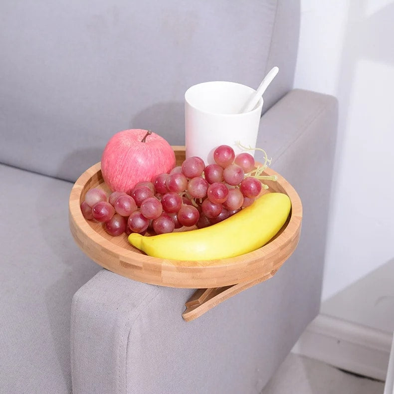Round bamboo tray clipped on the arm of a gray sofa