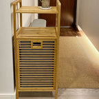 Tall bamboo storage cabinet with shelves and a slatted laundry compartment