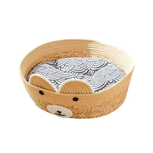 Round woven pet bed with a bear face and patterned cushion