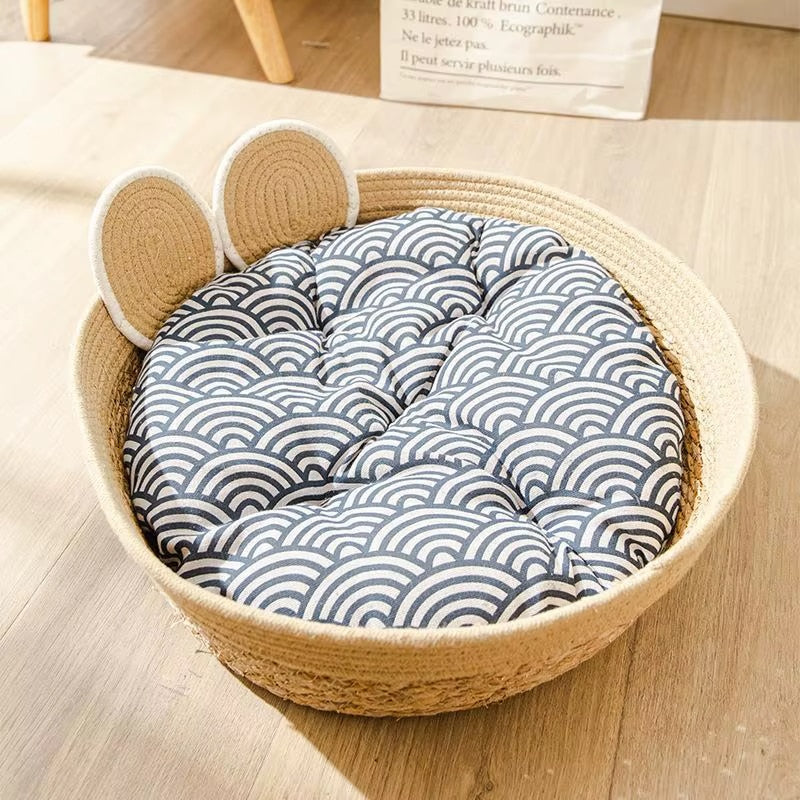 Round woven pet bed with a bear face and patterned cushion