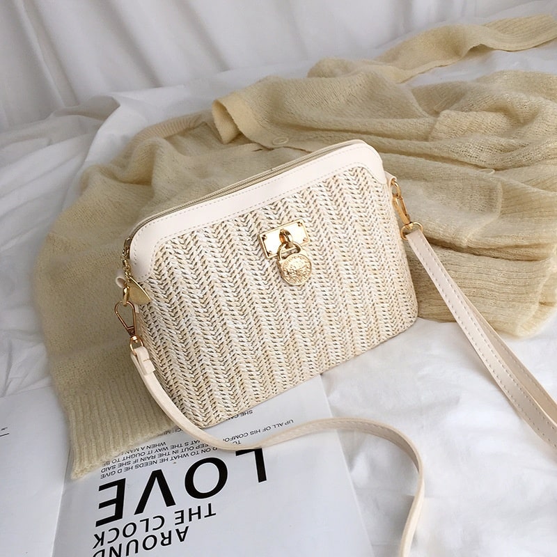 Rounded beige woven basket bag with a gold chain strap