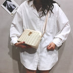 Rounded beige woven basket bag with a gold chain strap
