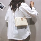 Rounded beige woven basket bag with a gold chain strap
