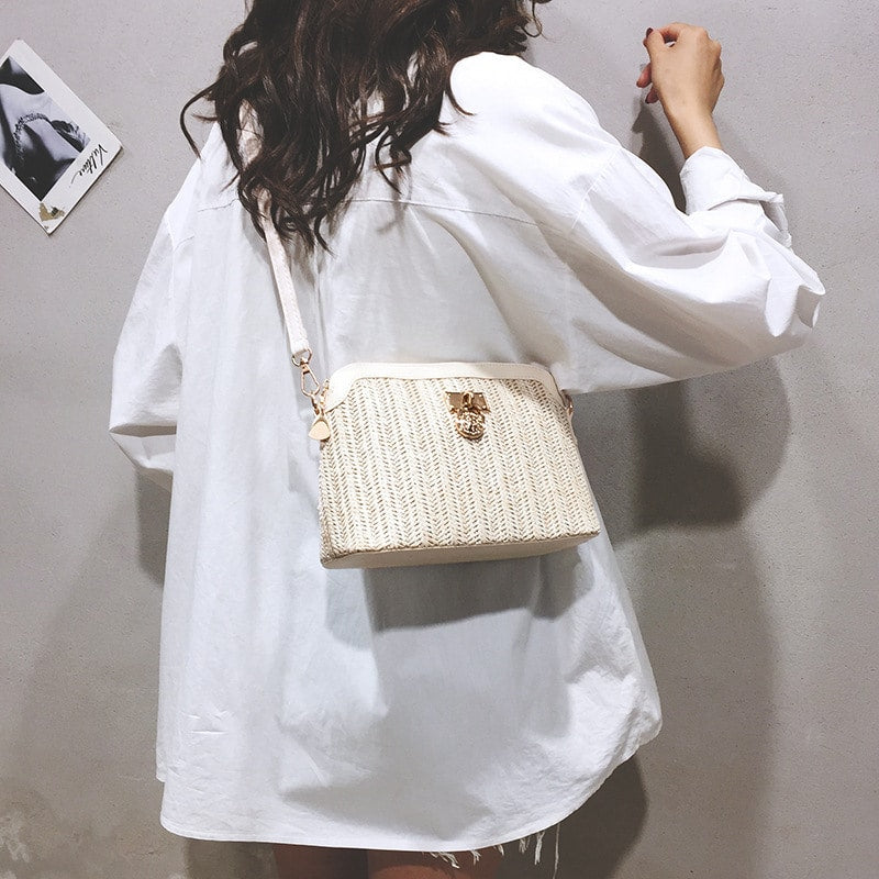 Rounded beige woven basket bag with a gold chain strap