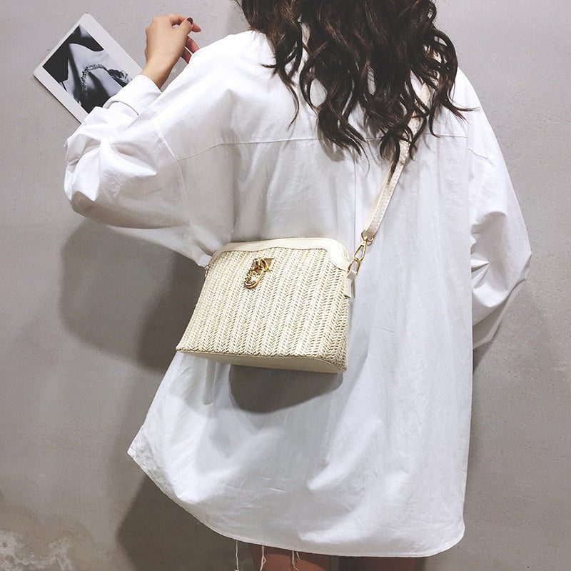 Rounded beige woven basket bag with a gold chain strap