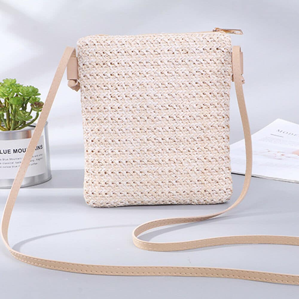 Compact beige woven straw and rattan crossbody bag with an adjustable strap