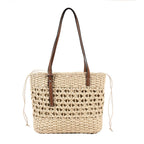 Rounded beige woven straw beach handbag with an adjustable strap