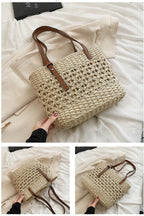 Rounded beige woven straw beach handbag with an adjustable strap