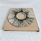 Round sunburst mirror with black and natural straw rays