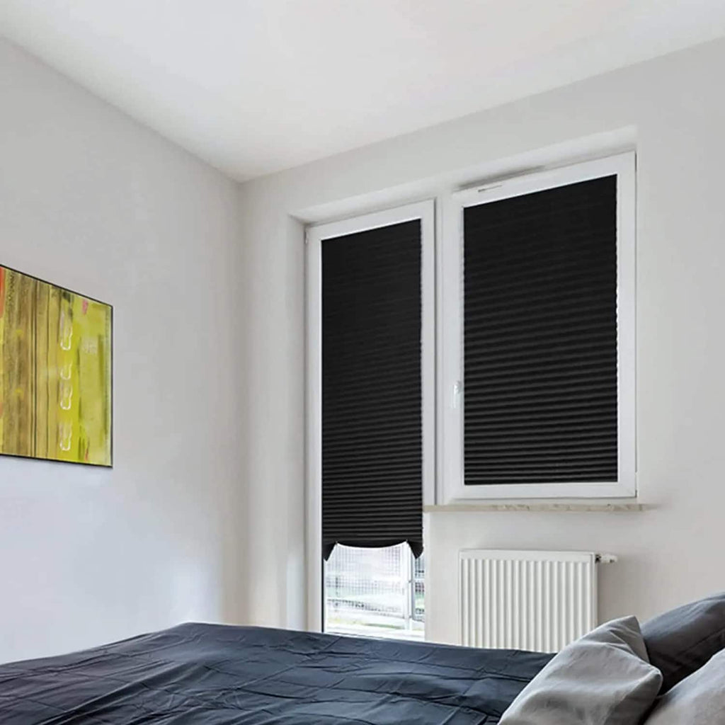 Black pleated shades clipped to two bedroom windows