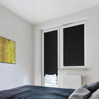 Black pleated shades clipped to two bedroom windows