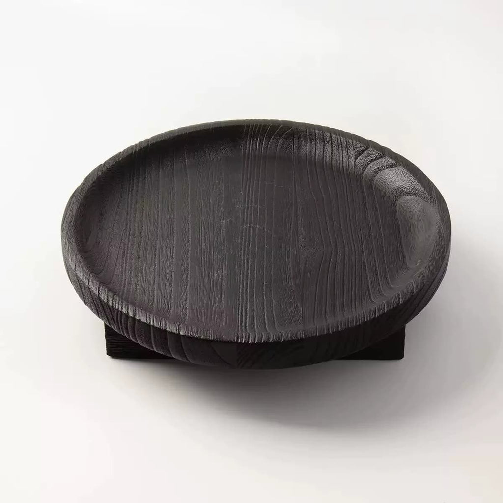 Round black wooden fruit bowl with visible wood grain