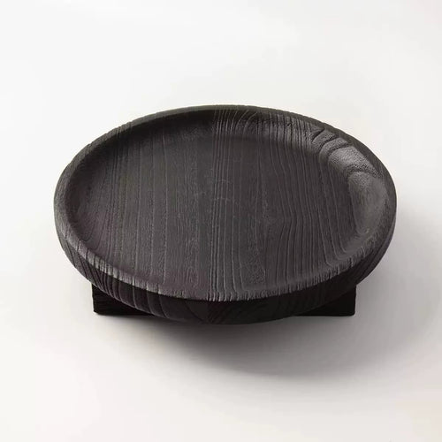 Round black wooden fruit bowl with visible wood grain