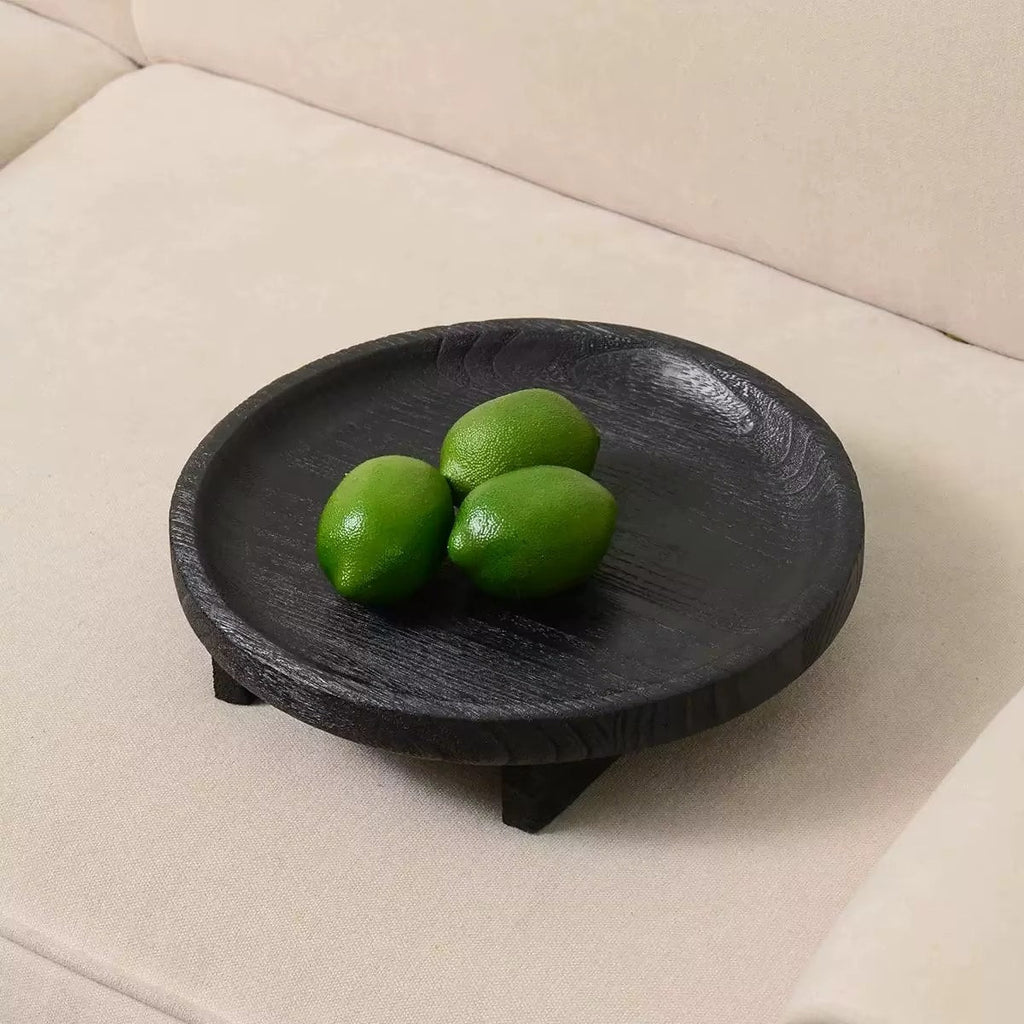 Round black wooden fruit bowl with visible wood grain