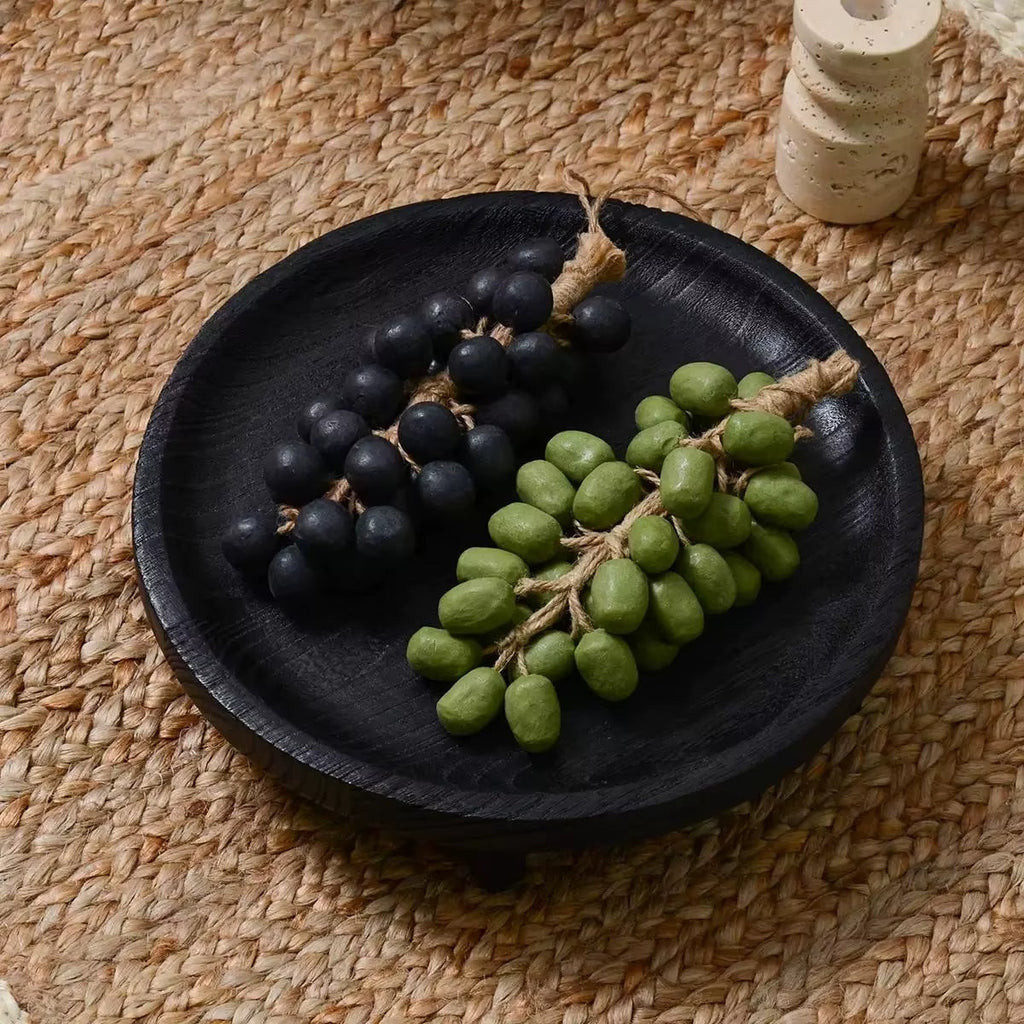 Round black wooden fruit bowl with visible wood grain