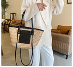 Structured black woven rattan beach bag with a handle and shoulder strap