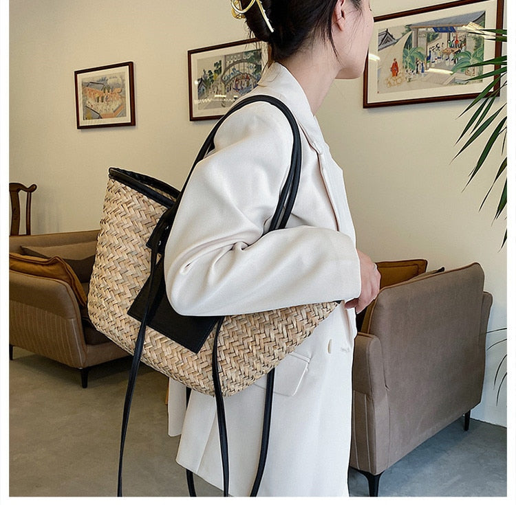 Structured black woven rattan beach bag with a handle and shoulder strap