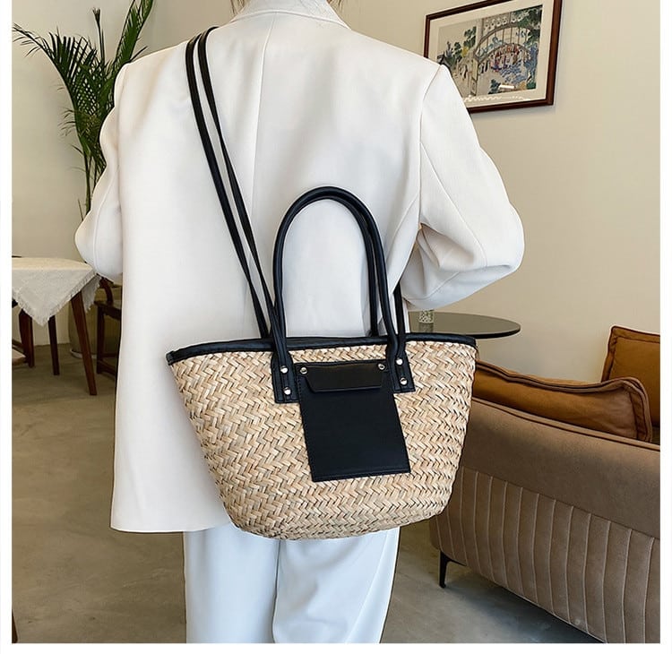 Structured black woven rattan beach bag with a handle and shoulder strap