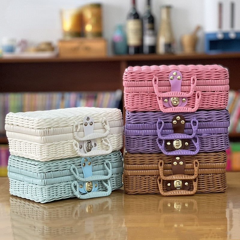 Small blue woven rattan box shaped like a retro suitcase with straps