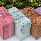 Small blue woven rattan box shaped like a retro suitcase with straps
