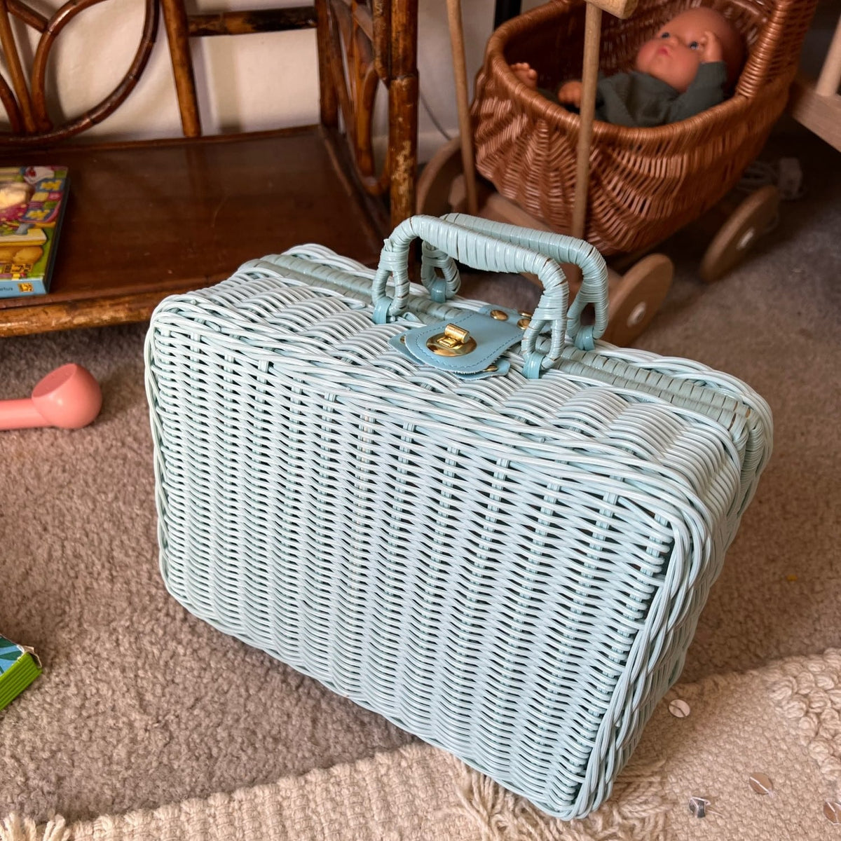 Small blue woven rattan box shaped like a retro suitcase with straps