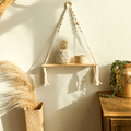 Boho hanging shelf of light wood held by hand knotted white macrame