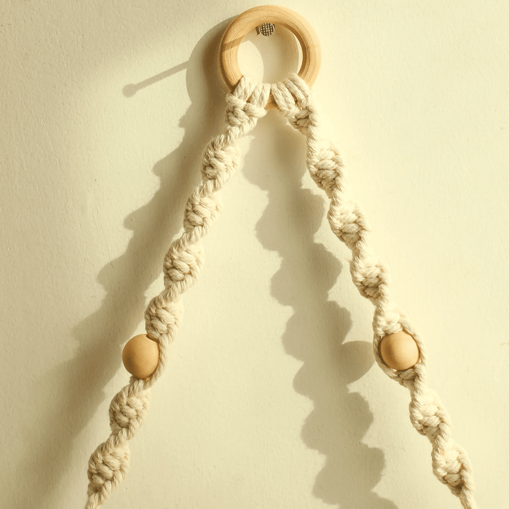 Boho hanging shelf of light wood held by hand knotted white macrame