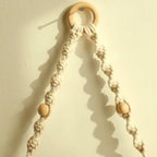 Boho hanging shelf of light wood held by hand knotted white macrame