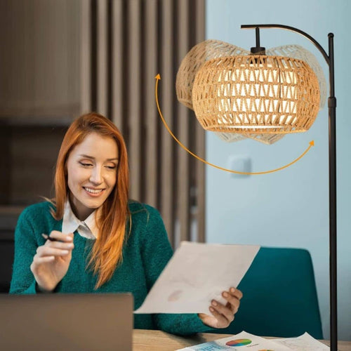 Boho floor lamp with a hand woven rattan shade on a slim black stand