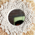 Round mirror framed by straw fringe and cotton macrame mandala