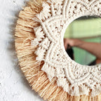 Round mirror framed by straw fringe and cotton macrame mandala