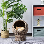 Round braided cat bed on a braided pedestal with a beige cushion
