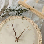Round wall clock with a braided rattan rim and beige dial