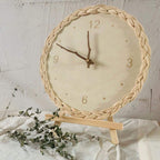 Round wall clock with a braided rattan rim and beige dial