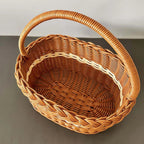 Oval wicker basket with braided rim and arched handle