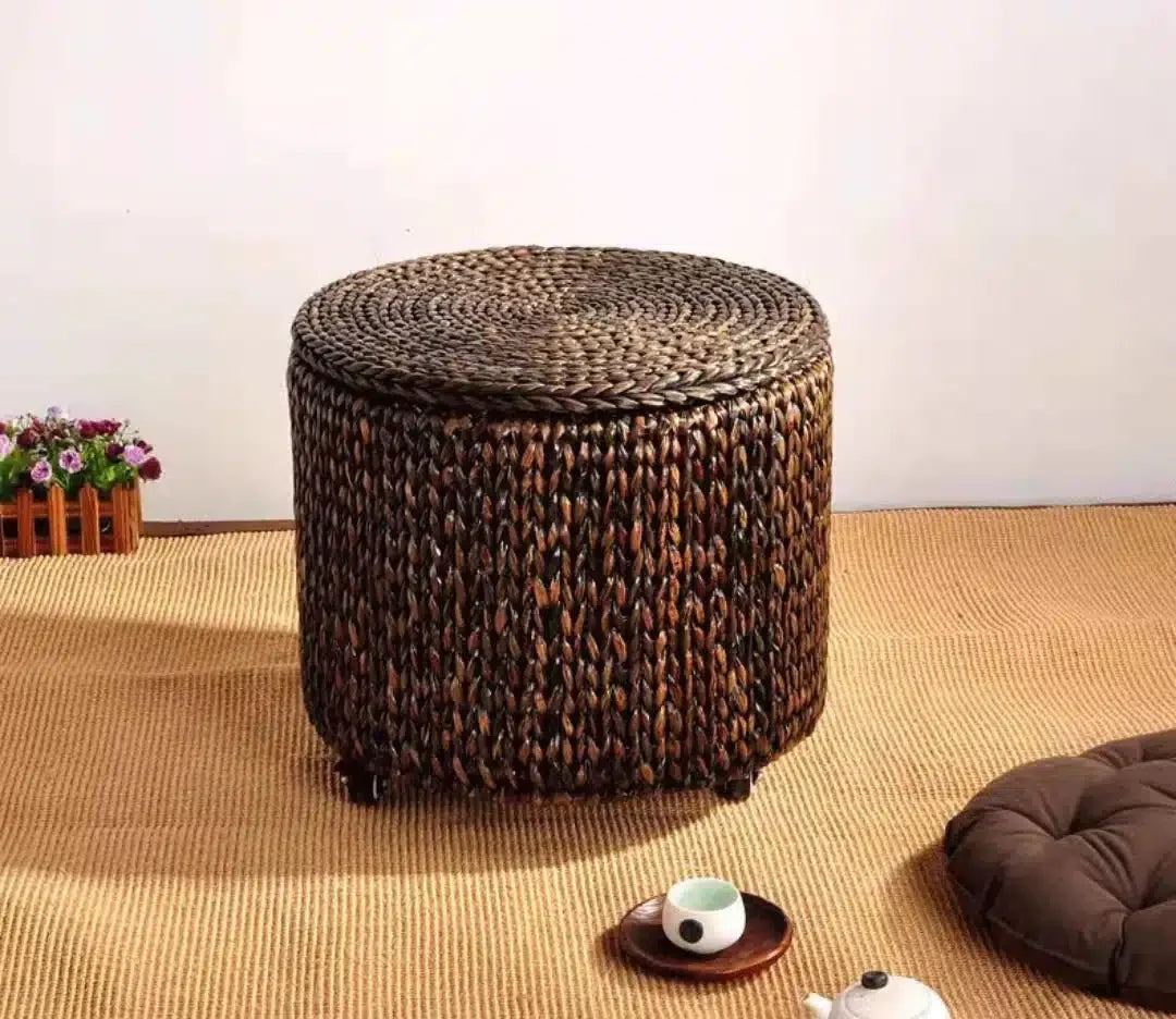 Brown hand woven rattan footstool on casters with a lift off lid