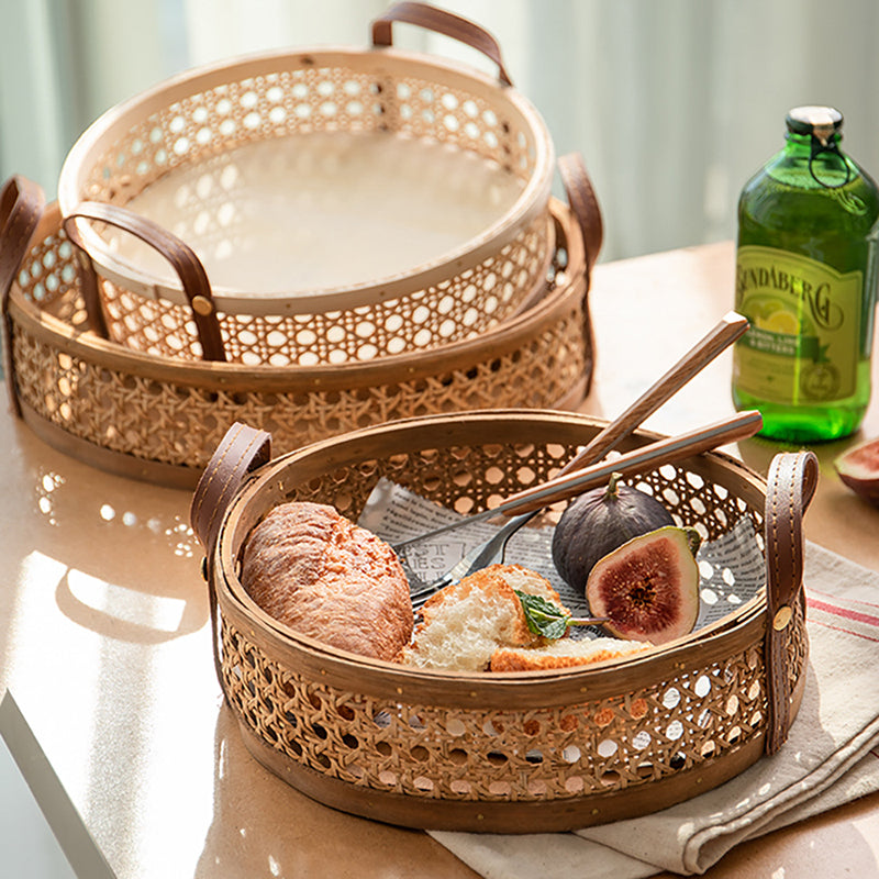 Round brown rattan storage tray with stitched leather handles