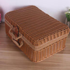 Small brown woven rattan box shaped like a retro suitcase with straps