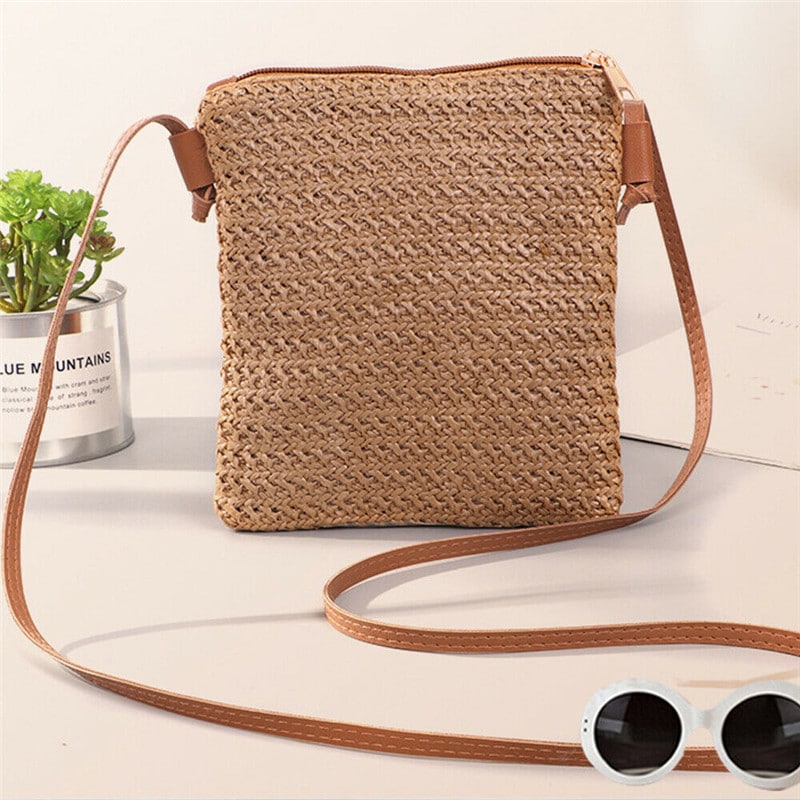 Compact brown woven straw and rattan crossbody bag with an adjustable strap