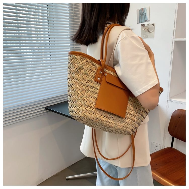 Structured brown woven rattan beach bag with a handle and shoulder strap