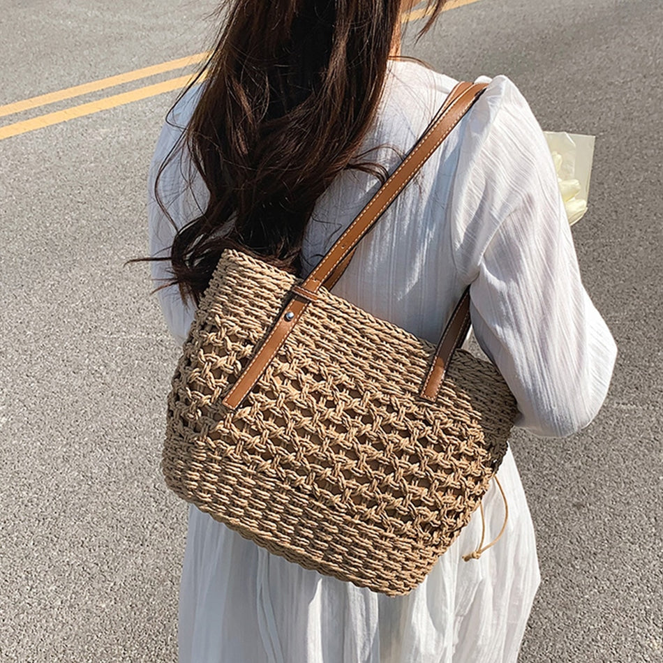 Caramel brown woven straw beach handbag with a braided cord strap