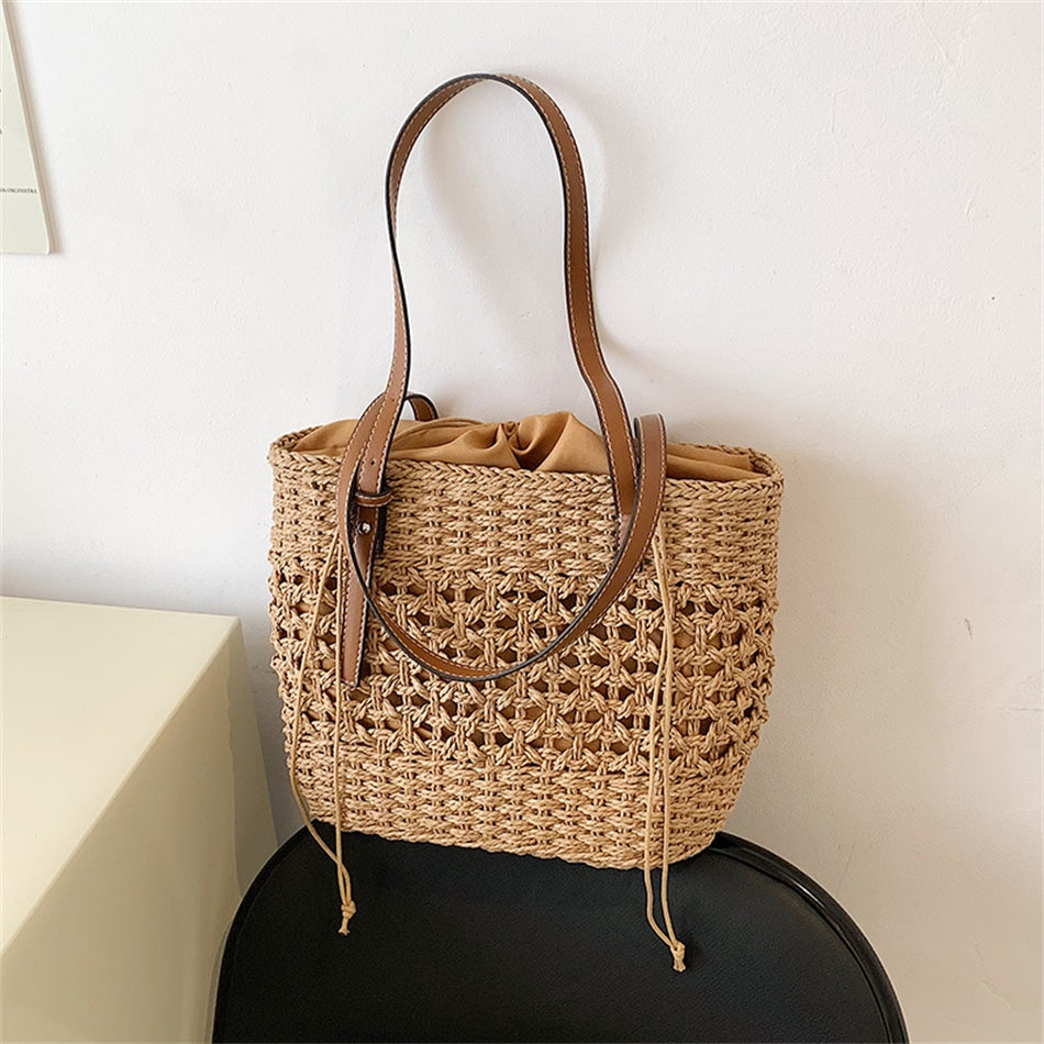 Caramel brown woven straw beach handbag with a braided cord strap