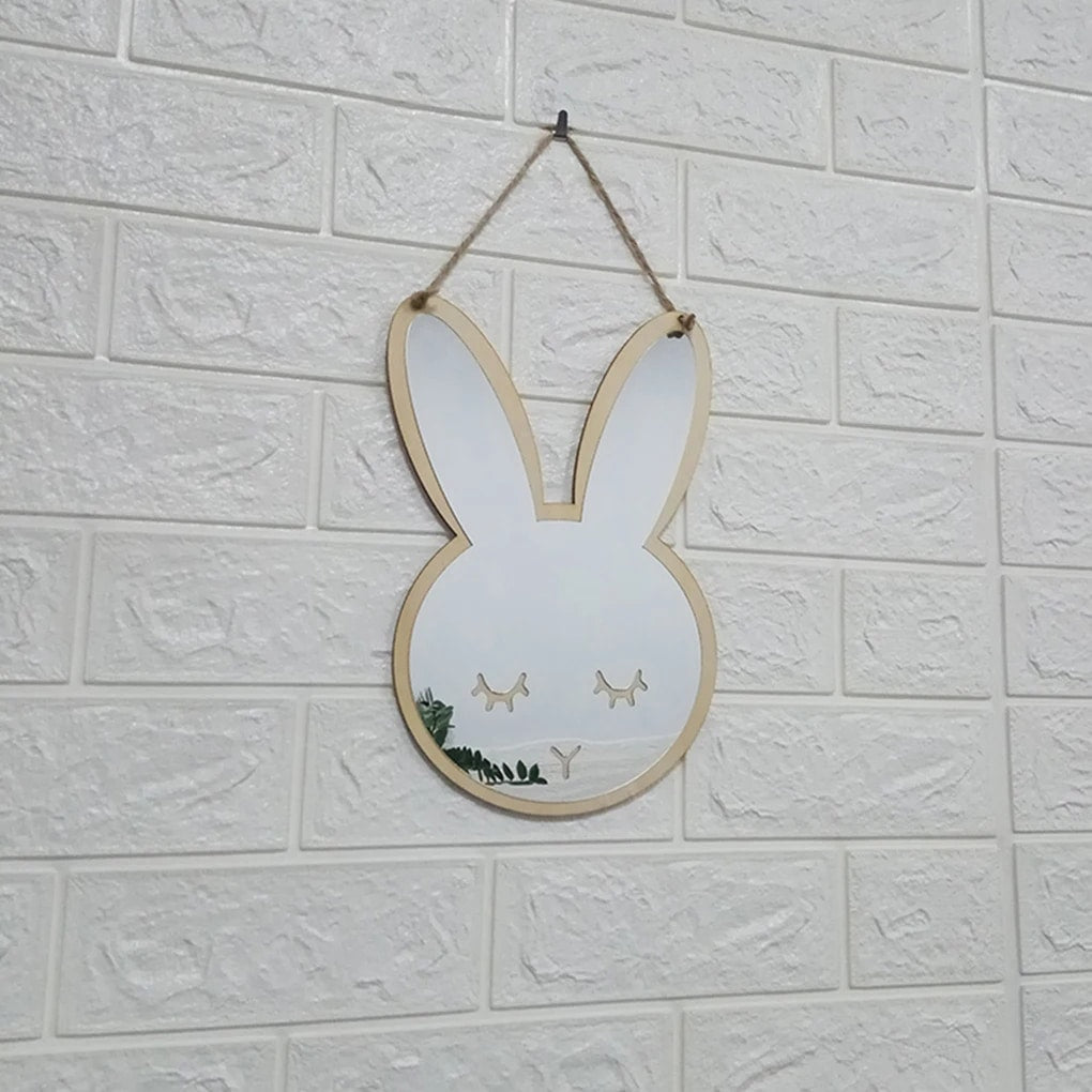 Bunny shaped wooden wall mirror hanging on a white brick wall