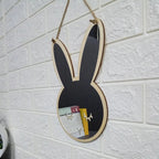 Bunny shaped wooden wall mirror hanging on a white brick wall