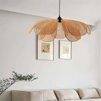 Flower shaped pendant light with woven cane petals over a sofa