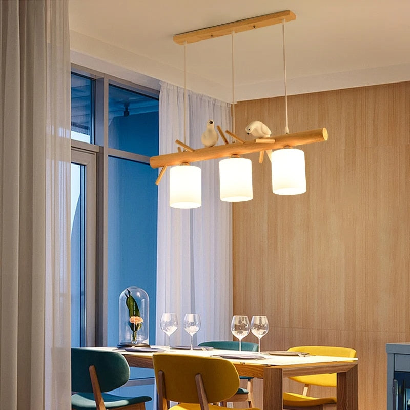 Wooden branch pendant light with small carved birds perched on it
